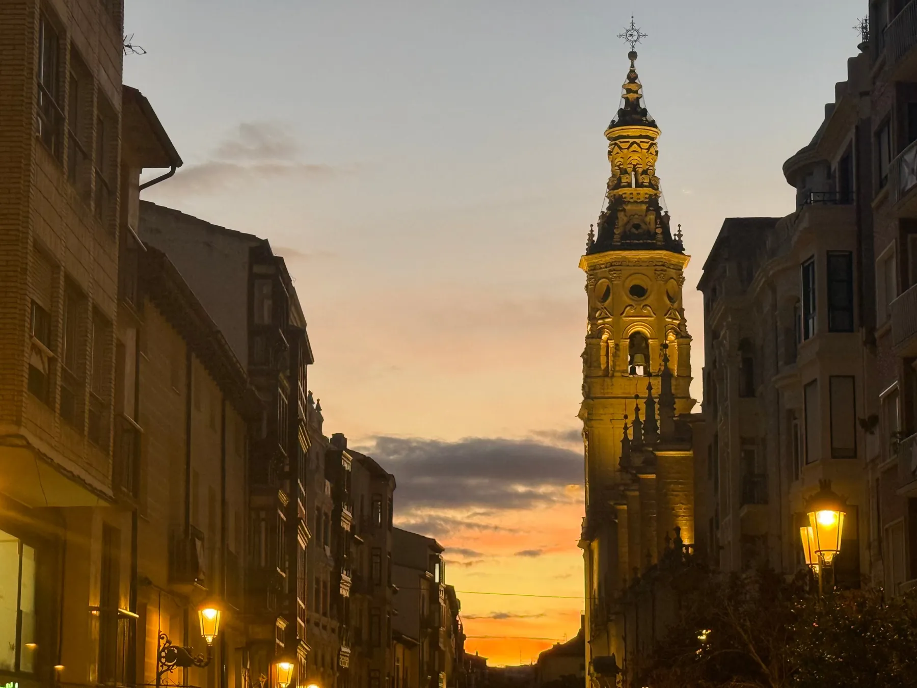 Torre iluminada al anochecer entre edificios